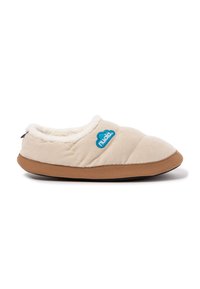 Zapatilla de casa de felpa beige con parte superior acolchada, forro de pelo sintético blanco, suela de goma marrón y acento de logo azul en forma de nube en el costado.