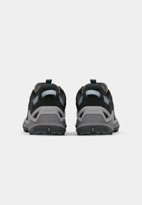 Black and gray hiking shoes with textured fabric, mesh accents, and a rugged outsole. Blue logo on the heel. Durable and supportive design.