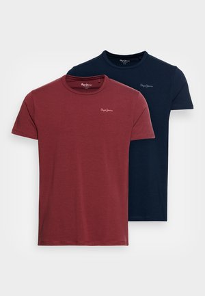 Dve polo tričká s krátkym rukávom: jedno v burgundskej farbe, druhé v námorníckej. Obe majú okrúhly výstrih a malé logo na hrudi. Mäkký bavlnený materiál.