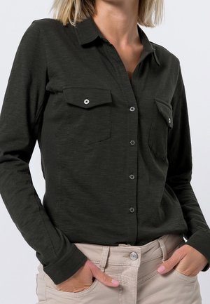 Long-sleeve dark green shirt with a button-down collar, two chest pockets, and silver button accents. Soft fabric and fitted design.