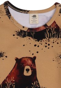 Shortsleeve-Shirt aus Bio-Baumwolle in Beige mit einem Bären-Graphic, schwarzen Akzenten und subtilen Pflanzendesigns, versehen mit einem Etikett mit Markeninformationen.