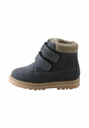 Blå velour ankelstøvler med to velcrolukninger, faux fur foring og en tan gummisål. Har kontrasterende syninger.