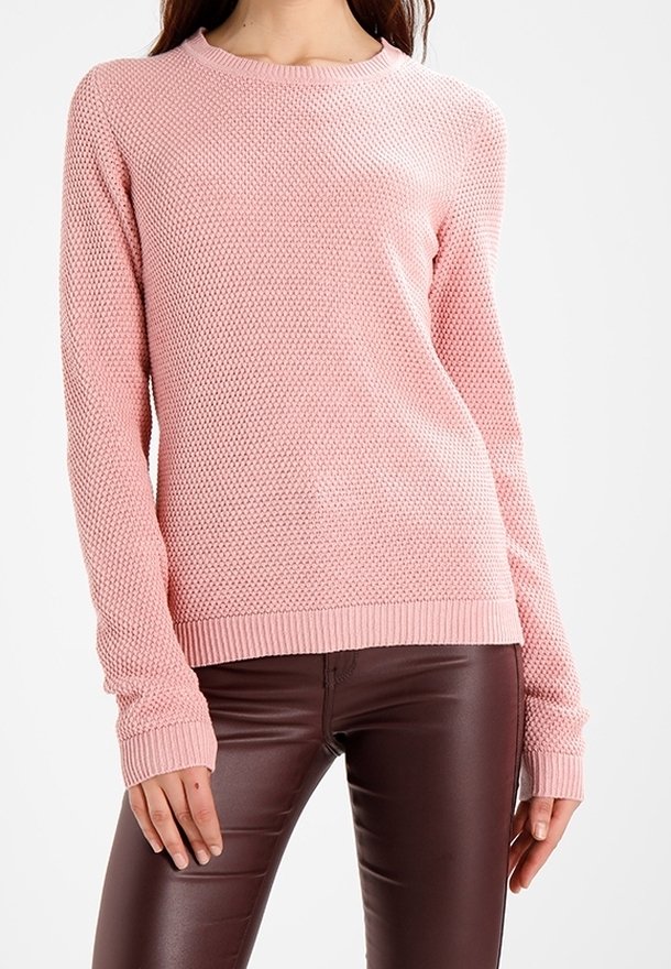 Light pink knit sweater with a textured pattern, ribbed crew neckline, and cuffs, paired with brown leather-like pants.