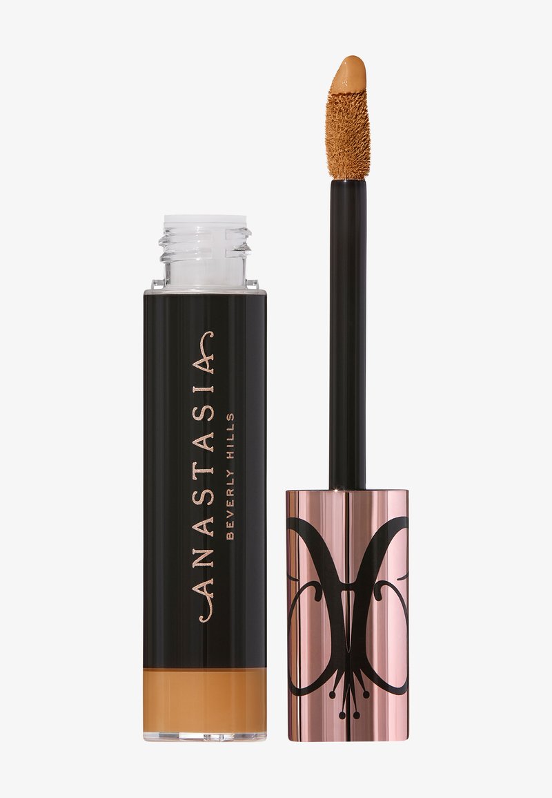 Liquid concealer in a clear tube with a black cylindrical cap, featuring a rose gold section adorned with a butterfly graphic. Included applicator.