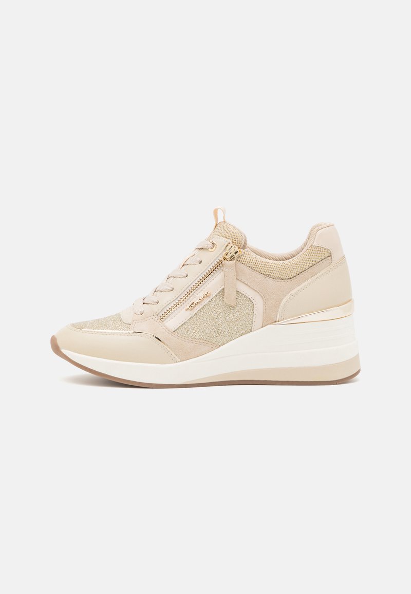 Beige sneakers met een gestructureerde stof en suède bovenwerk, voorzien van een gouden ritsdetail, wigzool en contrasterende witte tussenzool.