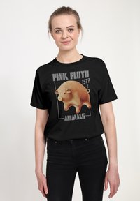 Černé bavlněné tričko s grafikou stylizované růžové prase, doplněné textem "PINK FLOYD 1977 ANIMALS" v šedé barvě.