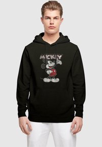 Svart hettegenser med lommer foran som har et grafisk bilde av Mikke Mus i rødt og grått. Teksten over leser "MICKEY" i en stilisert skrifttype.