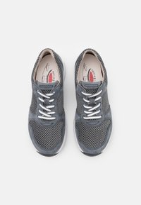 Grå mesh sneakers med mockadetaljer, vita snörningar, vadderad plös och en flexibel gummisula. Interiören har en märkesinläggssula.