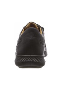 Chaussure en cuir noir avec un dos arrondi, semelle en caoutchouc texturé et doublure intérieure jaune contrastante. Design minimaliste avec des coutures discrètes.
