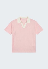 Polo rose clair à manches courtes en tissu texturé avec col blanc, avec un petit logo blanc brodé sur la poitrine gauche.