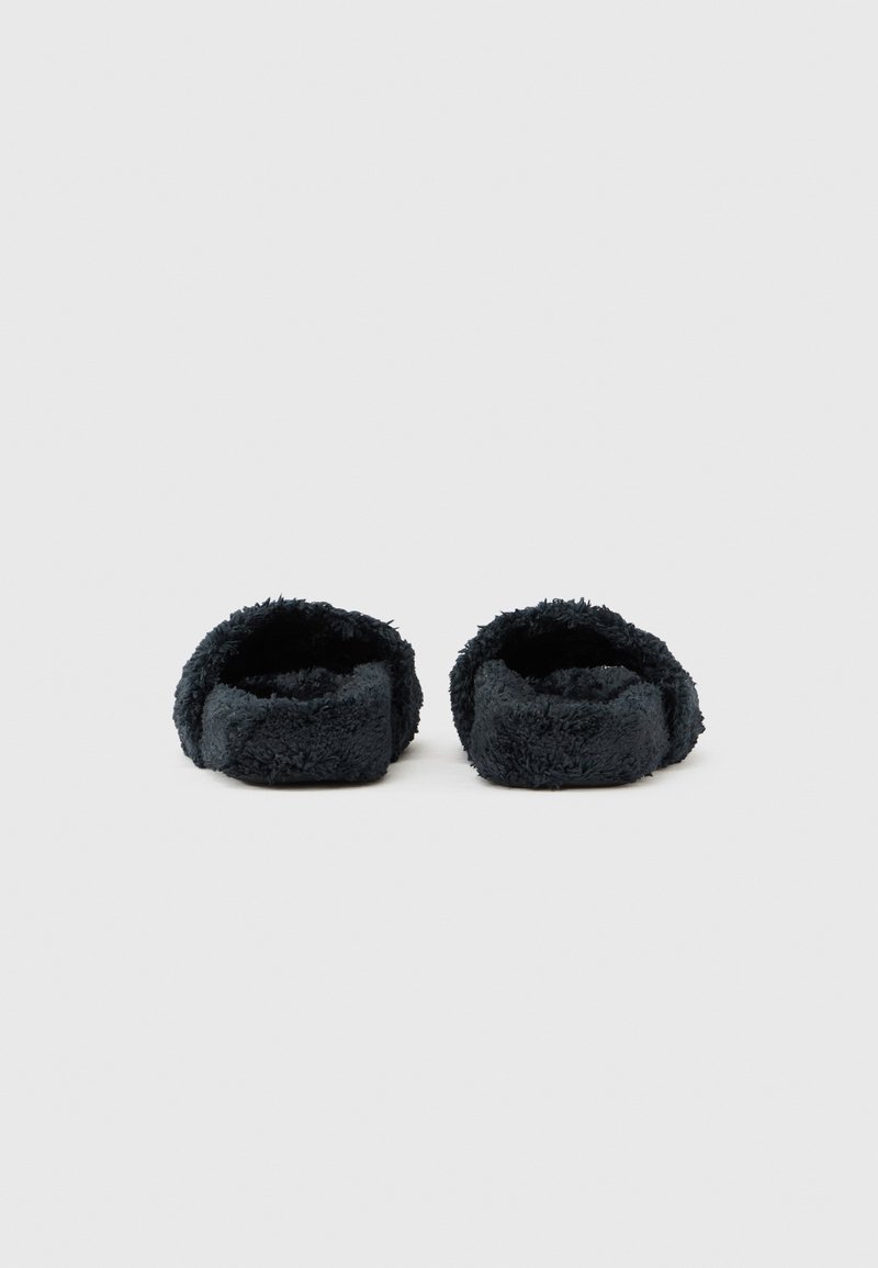 Pair of black fuzzy open-back slippers positioned side by side on a plain white background.