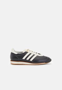 Navy leather sneaker with white three-stripe design, lace-up front, cream accents, and a gum rubber sole featuring a zigzag pattern.