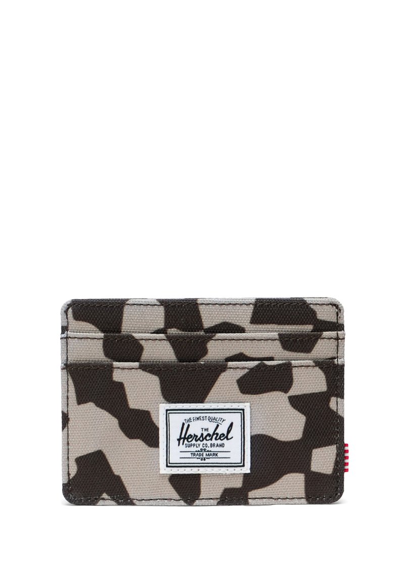 Maastokuvioitu kangaskorttikotelo, jossa on kolme taskua ja valkoinen suorakaiteen muotoinen merkki etupuolella, jossa lukee "Herschel Supply Co. Brand".