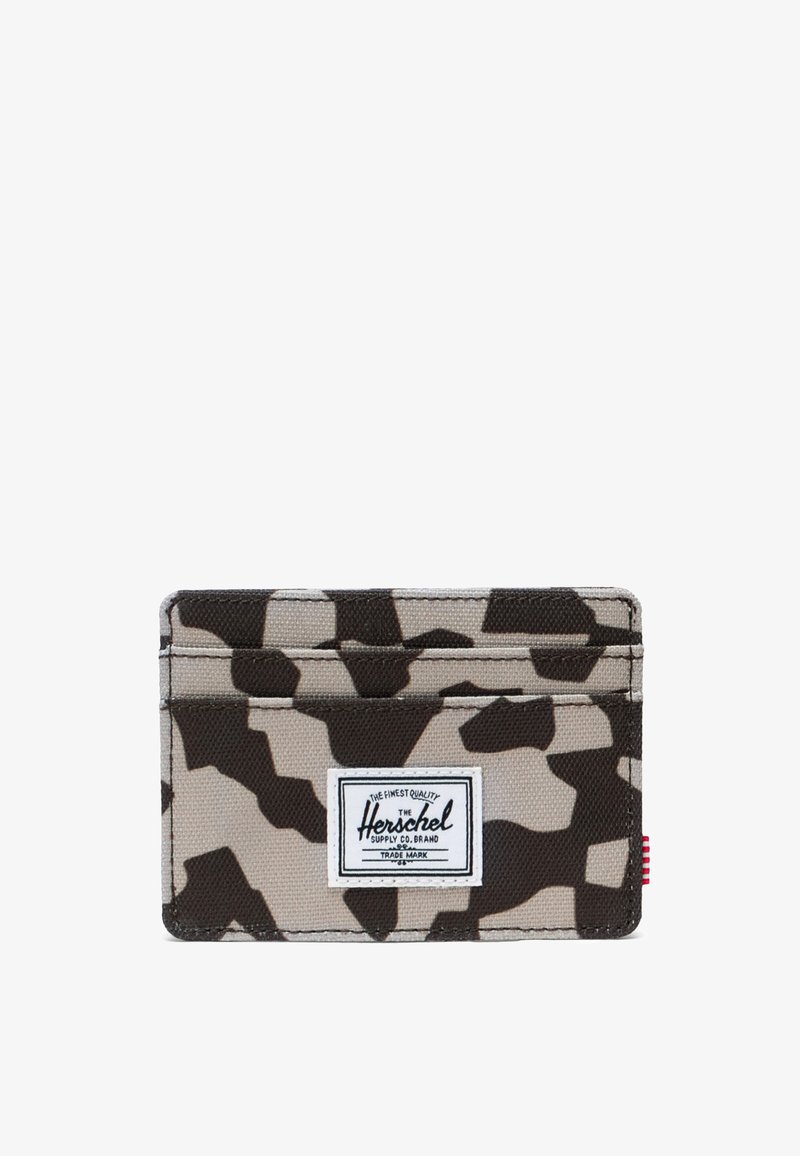 Maastokuvioitu kangaskorttikotelo, jossa on kolme taskua ja valkoinen suorakaiteen muotoinen merkki etupuolella, jossa lukee "Herschel Supply Co. Brand".