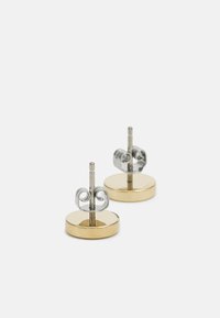 Boucles d'oreilles en métal doré et argenté avec des bases circulaires et de délicates accents en forme de volutes. Fini lisse et tiges filetées pour un port sécurisé.