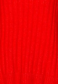 Roter gestrickter Pullover mit gerippter Textur, der dezente glänzende Fäden enthält. Nahaufnahme des Stoffmusters und der Farbe.