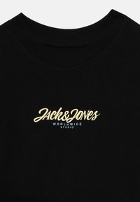 Black cotton t-shirt featuring a round neckline and a central logo in cursive white and blue text reading "Jack & Jones Worldwide Studio."