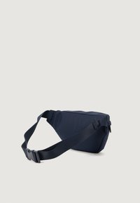 Tamsiai mėlyna nailoninė liemenėlė su trikampiu pavidalu. Yra reguliuojama diržo juosta ir metalinis sagtis. Tekstūruotas paviršius su minimalistišku dizainu.