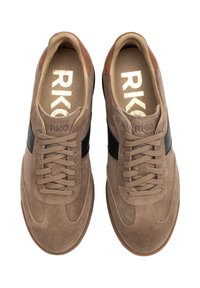 Brązowe zamszowe sneakersy z czarnym paskiem po boku, płaskimi sznurówkami i teksturowaną gumową podeszwą. Złote logo widoczne na wkładce.