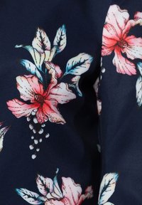 Ciemnoniebieska tkanina z dużymi różowymi i białymi wzorami kwiatowymi oraz szczegółowymi zielononiebieskimi liśćmi rozrzuconymi po powierzchni.