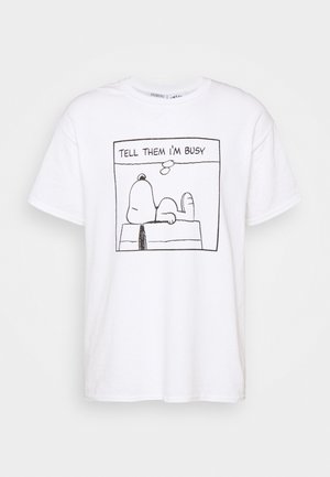 Biała koszulka z czarną liniową ilustracją Snoopy'ego leżącego na swojej budzie i napisem powyżej "POWIEDZ IM, ŻE JESTEM ZAJĘTY".