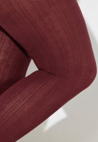 Bordowe rajstopy z fakturowanym wzorem w kształcie diamentu, półprzezroczyste, o gładkiej powierzchni, doskonale dopasowujące się do nogi.