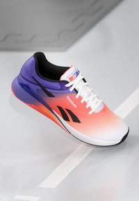Reebok running shoe featuring a gradient design from pink to purple, breathable mesh upper, black accents, and white laces.