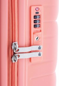 Hellrote Reisetasche mit TSA-zugelassenem Schloss, doppelten silbernen Reißverschlüssen und strukturierter Oberfläche mit Rillen für besseren Halt.