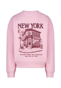 Sweatshirt rose avec une illustration graphique d'un magasin de bagels et le texte "NEW YORK". Les détails incluent un auvent rayé et un lampadaire.