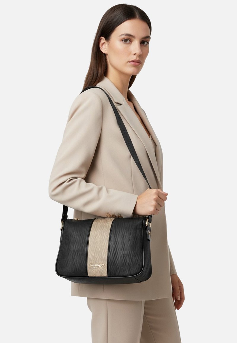 Borsa nera e beige con un design strutturato e superficie traforata. Dotata di una tracolla lunga e dettagli in metallo dorato.