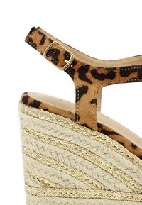 Leopard print wedge sandal with a suede upper and a textured straw heel featuring gold thread accents, adjustable ankle strap, and a rounded toe.