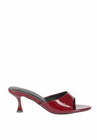 Mule in vernice rossa con tacco alto presentano un design open-toe, un tacco affusolato e una soletta nera liscia con una silhouette minimalista.