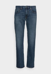 Jean en denim bleu foncé, coupe droite. Comprend cinq poches, quincaillerie en cuivre et un effet légèrement délavé sur le devant. Texture lisse.