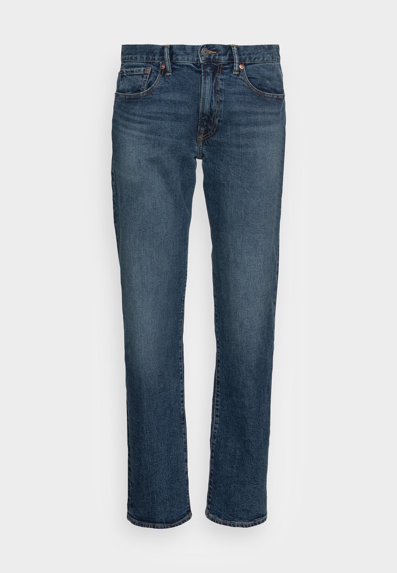 Jean en denim bleu foncé, coupe droite. Comprend cinq poches, quincaillerie en cuivre et un effet légèrement délavé sur le devant. Texture lisse.