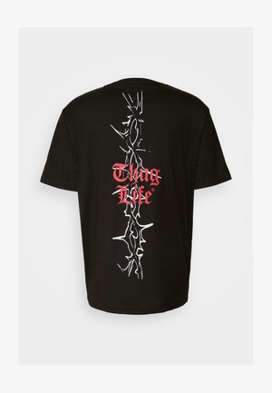 Black cotton t-shirt featuring white thorn-like graphic and red "Thug Life" text centered on the back. Short sleeves, regular fit.