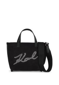 Fekete válltáska rövid fogantyúkkal, széles állítható vállpánttal, és "Vol" felirattal ezüst rhinestone díszítéssel az elülső panelen.