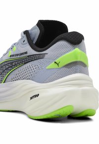 Zapatilla de running gris claro con parte superior de malla, acentos en verde neón, ribete negro en el collar y suela blanca acolchada con agarre texturizado.