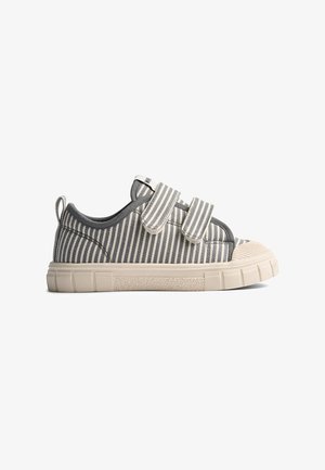 Scarpa da bambino a righe grigie e bianche con due cinturini in velcro e suola e punta in gomma beige, vista laterale su sfondo bianco.