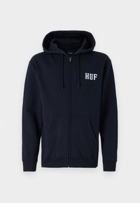 Hanorac cu fermoar de culoare bleumarin, fabricat din bumbac, cu glugă cu șnur, buzunare frontale și logo-ul alb "HUF" pe pieptul stâng. Textură moale.