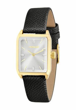 Prostokątny złoty zegarek ze srebrną tarczą, złotymi indeksami godzin i wskazówkami, czarnym paskiem ze skóry o fakturze oraz nazwą marki "Cacharel" na tarczy.