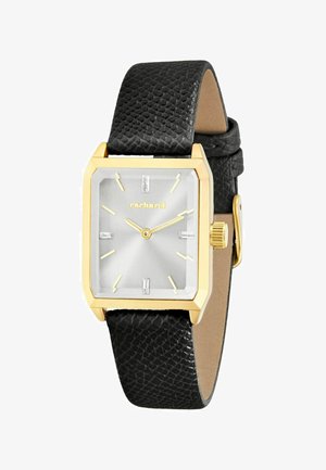 Rechthoekig gouden horloge met zilverkleurige wijzerplaat, gouden uurmarkeringen en wijzers, zwarte leren band met structuur en merknaam "Cacharel" op de wijzerplaat.