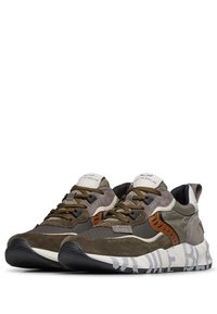 Sneaker con una combinazione di suede verde oliva e mesh, dettagli in pelle marrone, suola bianca spessa con dettagli grigi e lacci texture.