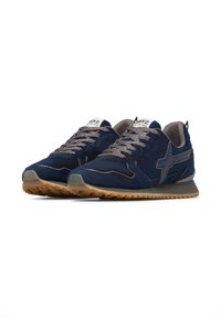 Scarpe sportive in camoscio navy con suola in gomma, lacci grigi e logo laterale. Presentano una punta rotonda e dettagli testurizzati sulla tomaia.