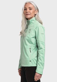 Mintgrüne Softshelljacke mit hohem Kragen, durchgehendem Reißverschluss und seitlichen Reißverschlusstaschen; verfügt über ein Logo auf der Brust und ist bequem geschnitten.