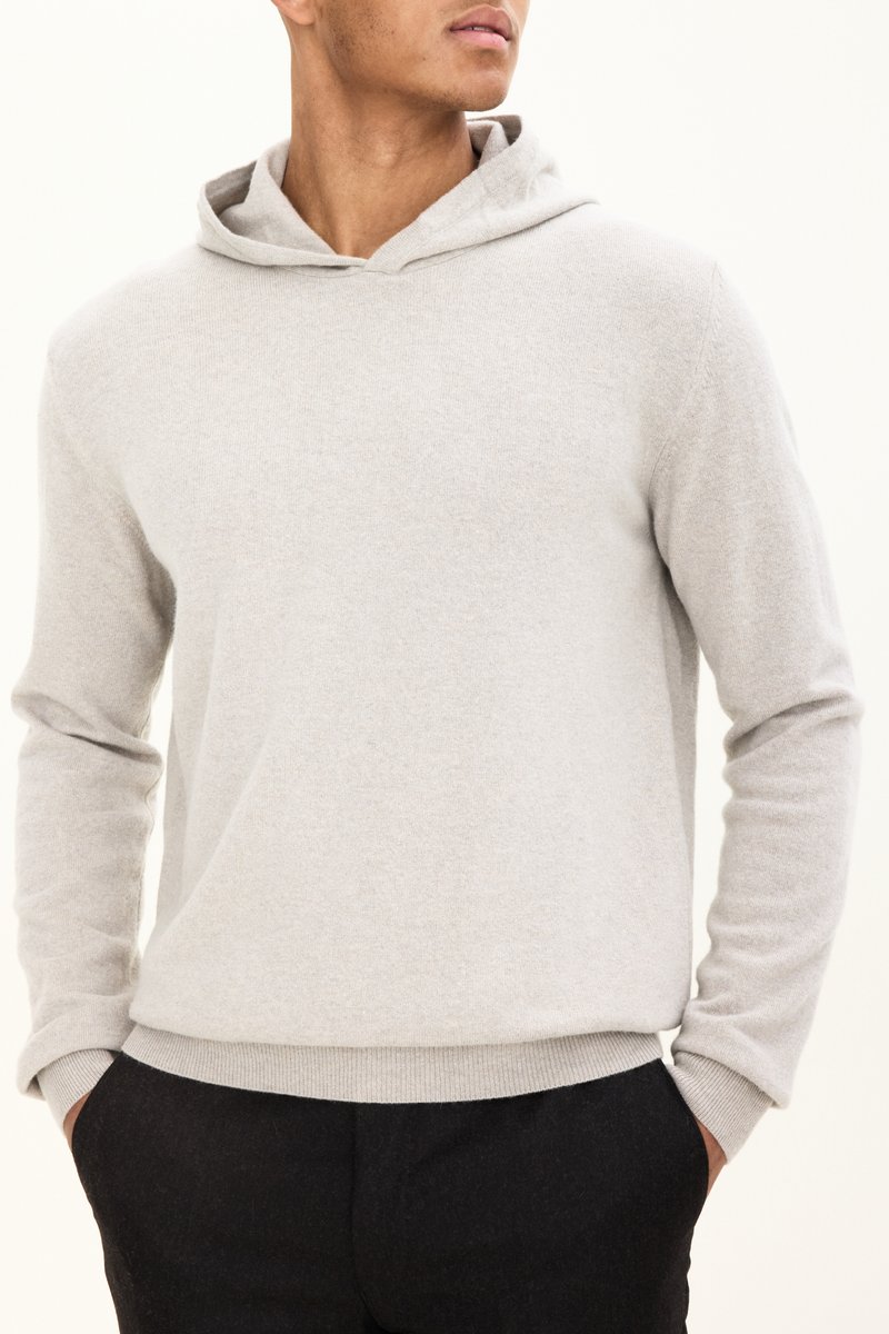 Hellgrauer Kapuzenpullover aus weichem Stoff, mit langen Ärmeln und lockerer Passform. Saum und Bündchen sind mit Rippstrick versehen.