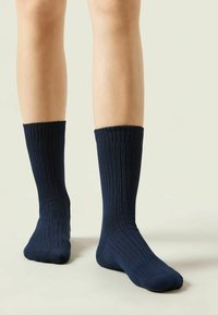 Calcetines acanalados de un azul marino oscuro con un patrón de tejido texturado, que presentan una altura hasta la mitad de la pantorrilla y un puño elástico para un ajuste seguro.