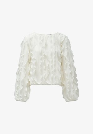 Blusa blanca corta con detalles de volantes en el frente y las mangas, hecha de una tela texturizada ligera. Escote redondo.