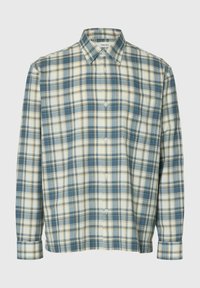 Chemise à manches longues à boutons avec un motif à carreaux bleu, blanc et beige et une poche poitrine, présentée sur un fond uni.