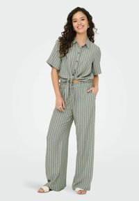 Groene en witte gestreepte bijpassende set bestaande uit een kortärmidige overhemd met een geknoopt voorpand en wijde broekspijpen. Gladde stof, casual pasvorm.