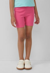 Roze ribstof shorts met een aansluitend ontwerp, met een gladde textuur en een lengte tot halverwege de dij, gecombineerd met witte canvas schoenen.